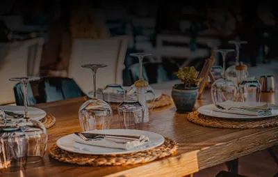 Una mesa de La Bella Lola preparada con platos, cubiertos y copas.